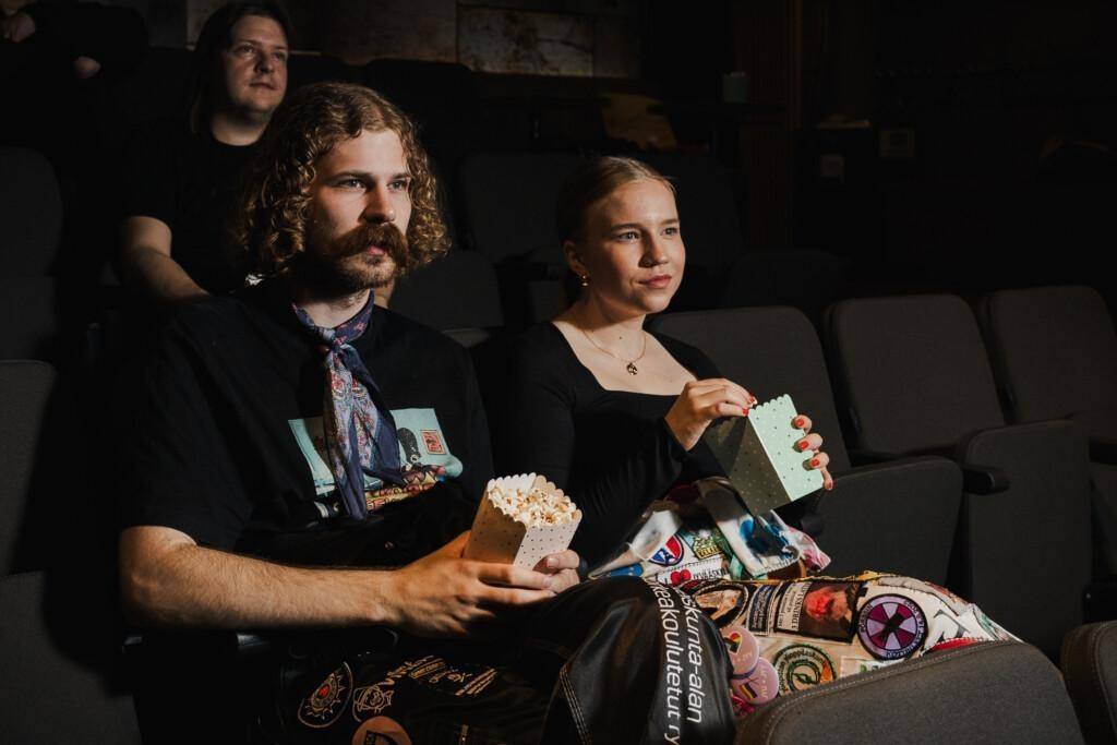 Ihmisiä Ilokivi Venuen elokuvakatsomossa keskittyneinä elokuvaan. Tarjolla on popcornia.